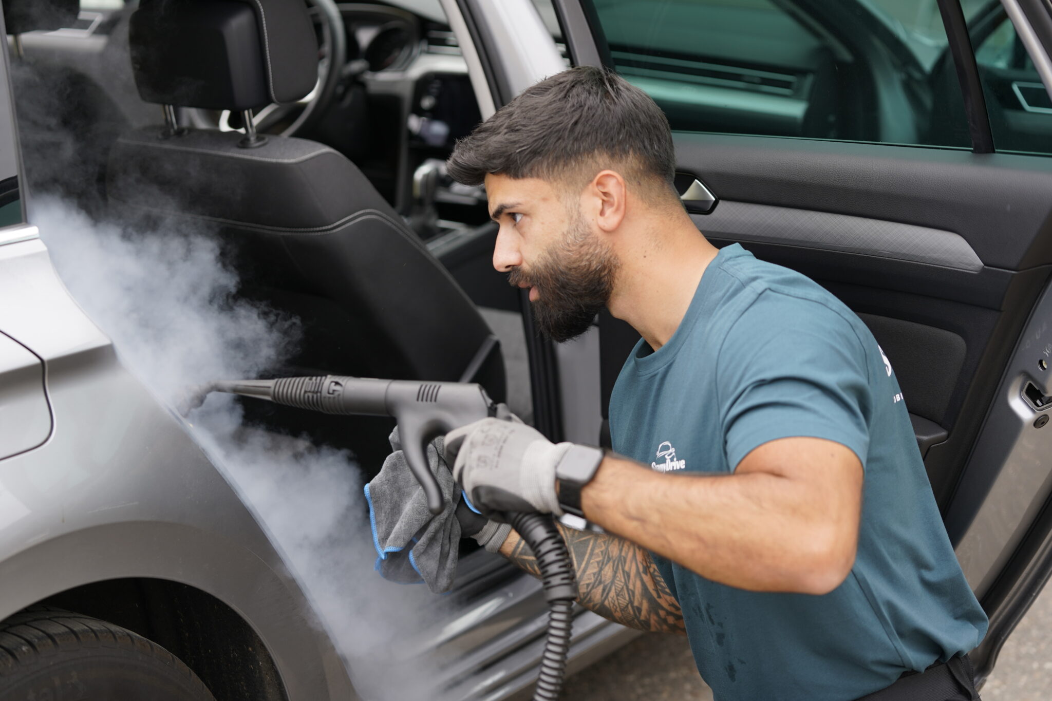Mobile Fahrzeugreinigung - SteamyDrive Mitarbeiter reinigt Türfalze und Einstiegsbereich mit Trockendampf – Mobile Fahrzeugreinigung bei SteamyDrive in Köln NRW